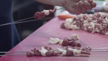 Schaschlik Kebab Meister bereitet vor Lamm Fleisch zum Kochen durch Bespannung es auf Spieße video