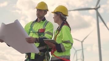 ingegneri Lavorando nel lavoro sul campo all'aperto. lavoratori a piedi e ispezionare costruzione e macchina in giro progetto luogo. vento turbina elettrico di pulito risorsa enerdy e ambiente sostenibile. video