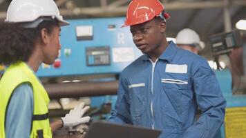 fábrica profesional africano y asiático trabajador y gerente inspector en máquina y discutir inspección alrededor fábrica. equipo ingenieros reparando para calidad y puesta en marcha pruebas antes de operación. video