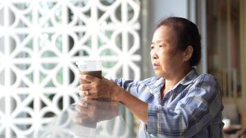 asiatique Sénior vieux femme est en buvant café et en marchant autour Extérieur piéton. video