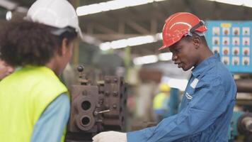 fabbrica professionale africano e asiatico lavoratore e manager ispettore su macchina e discutere ispezione in giro fabbrica. squadra ingegneri riparazione per qualità e la messa in produzione analisi prima operazione. video