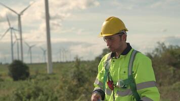 ingenieros hombre bebidas agua y soportes a construcción viento turbina. viento turbina para electricidad de limpiar energía y ambiente. concepto de éxito negocio de industrial de sostenibilidad. video