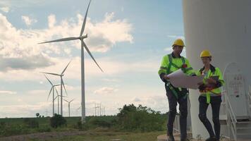 Ingenieure Arbeiten im Feldarbeit draussen. Arbeitskräfte Gehen und prüfen Konstruktion und Maschine um Projekt Seite? ˅. Wind Turbine elektrisch von sauber Ressource energetisch und Umgebung nachhaltig. video