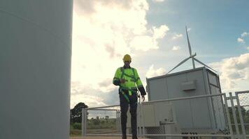 africano ingegnere Lavorando nel lavoro sul campo. lavoratore ispezionare costruzione e macchina in giro il progetto luogo. vento turbina elettrico di pulito risorsa energia e ambiente sostenibile. video