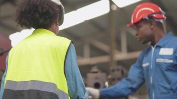 fábrica profesional africano y asiático trabajador y gerente inspector en máquina y discutir inspección alrededor fábrica. equipo ingenieros reparando para calidad y puesta en marcha pruebas antes de operación. video