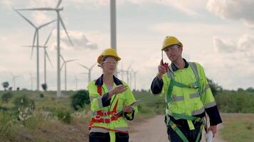 engenheiros trabalhando dentro trabalho de campo ar livre. trabalhadores caminhando e inspecionar construção e máquina por aí projeto local. vento turbina elétrico do limpar \ limpo recurso enérgico e meio Ambiente sustentável. video