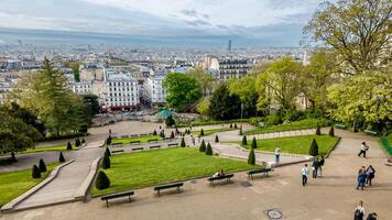 Panoramic view of Paris from Montmartre with people enjoying a serene spring day, ideal for travel and European culture themes photo