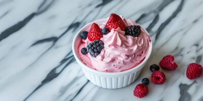 Fresh berry topped pink whipped cream dessert in a white ramekin on a marble backdrop, ideal for Valentines Day or Mothers Day culinary themes photo