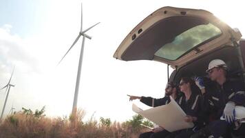 Ingenieure Arbeiten auf das Konstruktion Seite? ˅ von Wind Turbine Bauernhof. Wind Turbine mit ein Energie Lager System betrieben durch Super Energie Konzern. Arbeitskräfte Sitzung im van zum ruhen. video
