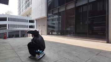 asiático hombre es bailando en cadera salto estilo a al aire libre espacio. profesional solo bailarín es ejecutando en público área. video