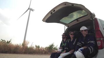 ingenieurs werken Aan de bouw plaats van wind turbine boerderij. wind turbine met een energie opslagruimte systeem bediend door super energie corporatie. arbeiders zittend in busje voor rusten. video