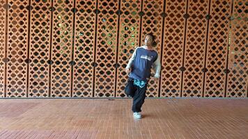 Aziatisch Mens is dansen in heup hop stijl Bij buitenshuis ruimte. professioneel solo danser is het uitvoeren van in openbaar Oppervlakte. video