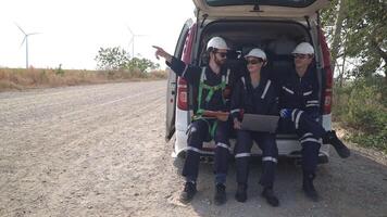 engineers working on the construction site of WIND TURBINE FARM. WIND TURBINE with an energy storage system operated by Super Energy Corporation. Workers sitting in van for resting. video