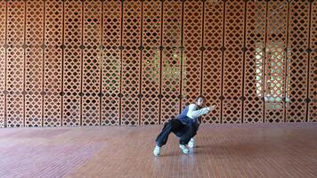 asiatisch Mann ist Tanzen im Hüfte hop Stil beim draussen Raum. Fachmann Solo Tänzer ist durchführen im Öffentlichkeit Bereich. video