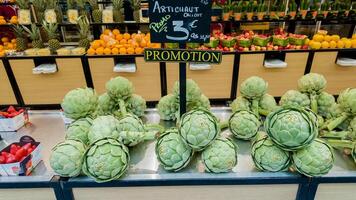 Fresh artichokes on display with promotional signage at a Parisian market, emphasizing healthy eating and local cuisine, captured in Paris, France, on April 14th, 2024 photo