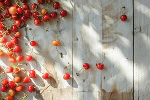 Overhead view of fresh cherries scattered on a light wooden table, natural sunlight photo