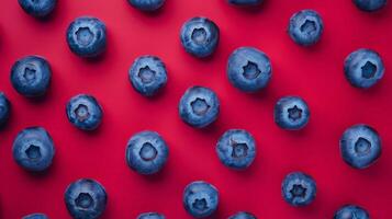 Abstract arrangement of blueberries forming a simple geometric pattern, isolated on red photo
