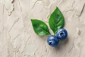 Blueberry with a leaf, centered on a soft textured beige background, minimalist natural theme photo