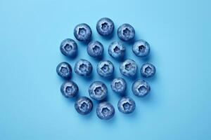 Abstract arrangement of blueberries forming a simple geometric pattern, isolated on blue photo