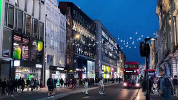 Oxford calle en el noche, con luces esclarecedor el ciudades icónico compras destino, lento movimiento video