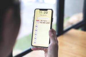 Reminder list concept. Woman uses smartphone application to record to-do list and reminders of important schedules, meeting appointments photo