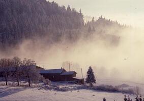 a snowy mountain with a house in the distance photo