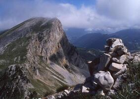 un rocoso montaña con un grande pila de rocas en parte superior foto