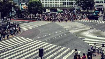 Crowds of people cross a street junction 4k background video