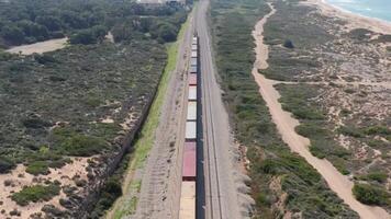 Freight train moving along the tracks next to the ocean 4k background video