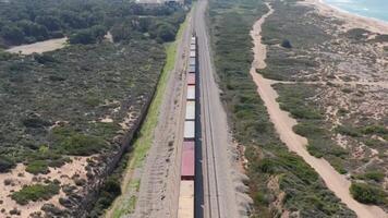 vracht trein in beweging langs de sporen De volgende naar de oceaan 4k achtergrond video