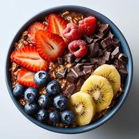 Chocolate oatmeal with a variety of fruits in blue bowl isolated on white background. Chocolate oatmeal with strawberries, blueberries and bananas top view photo