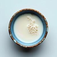 Milk in cup isolated on white background with shadow. Milk in blue cup full of calcium top view photo