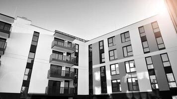 Fragment of the building's facade with windows and balconies. Modern apartment buildings on a sunny day. Facade of a modern residential building. Black and white. photo