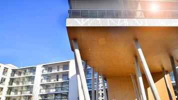 un Departamento edificio con un único arquitectónico solución. un moderno residencial edificio con un blanco fachada y en pie en alto hormigón pilares foto