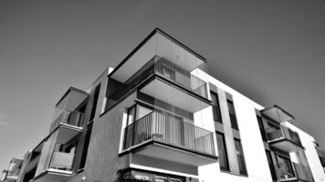 fragmento de el del edificio fachada con ventanas y balcones moderno Departamento edificios en un soleado día. fachada de un moderno residencial edificio. negro y blanco. foto