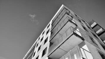 Fragment of the building's facade with windows and balconies. Modern apartment buildings on a sunny day. Facade of a modern residential building. Black and white. photo