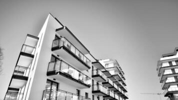 Fragment of a facade of a building with windows and balconies. Modern apartment buildings on a sunny day. Facade of a modern apartment building. Black and white. photo