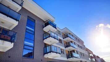 Modern apartment building in sunny day. Exterior, residential house facade. Residential area with modern, new and stylish living block of flats. photo