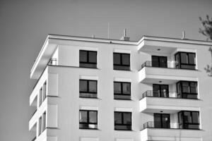 fragmento de un fachada de un edificio con ventanas y balcones moderno Departamento edificios en un soleado día. fachada de un moderno Departamento edificio. negro y blanco. foto