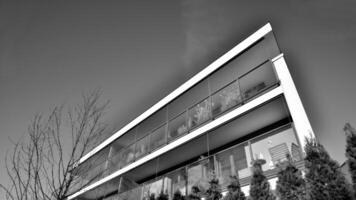 fragmento de un fachada de un edificio con ventanas y balcones moderno Departamento edificios en un soleado día. fachada de un moderno Departamento edificio. negro y blanco. foto