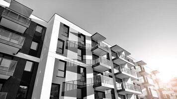 Fragment of the building's facade with windows and balconies. Modern apartment buildings on a sunny day. Facade of a modern residential building. Black and white. photo