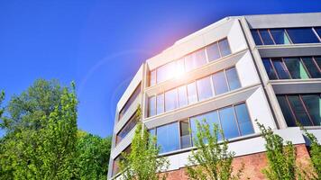 Eco architecture. Green tree and new residential building. Harmony of nature and modernity. Modern apartment building with new apartments in a green residential area. photo