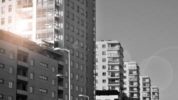 Fragment of the building's facade with windows and balconies. Modern apartment buildings on a sunny day. Facade of a modern residential building. Black and white. photo