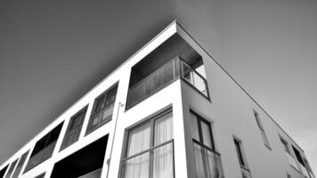 fragmento de un fachada de un edificio con ventanas y balcones moderno Departamento edificios en un soleado día. fachada de un moderno Departamento edificio. negro y blanco. foto