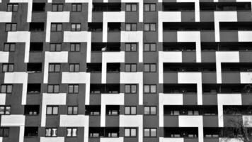 Fragment of the building's facade with windows and balconies. Modern apartment buildings on a sunny day. Facade of a modern residential building. Black and white. photo