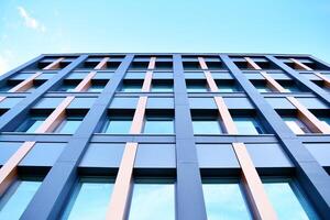 Glass building with transparent facade of the building and blue sky. Structural glass wall reflecting blue sky. Abstract modern architecture fragment. Contemporary architectural background. photo