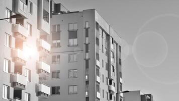 Fragment of the building's facade with windows and balconies. Modern apartment buildings on a sunny day. Facade of a modern residential building. Black and white. photo