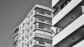 fragmento de el del edificio fachada con ventanas y balcones moderno Departamento edificios en un soleado día. fachada de un moderno residencial edificio. negro y blanco. foto