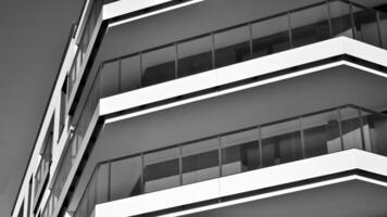 Fragment of the building's facade with windows and balconies. Modern apartment buildings on a sunny day. Facade of a modern residential building. Black and white. photo