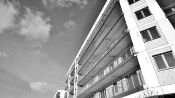Fragment of the building's facade with windows and balconies. Modern apartment buildings on a sunny day. Facade of a modern residential building. Black and white. photo